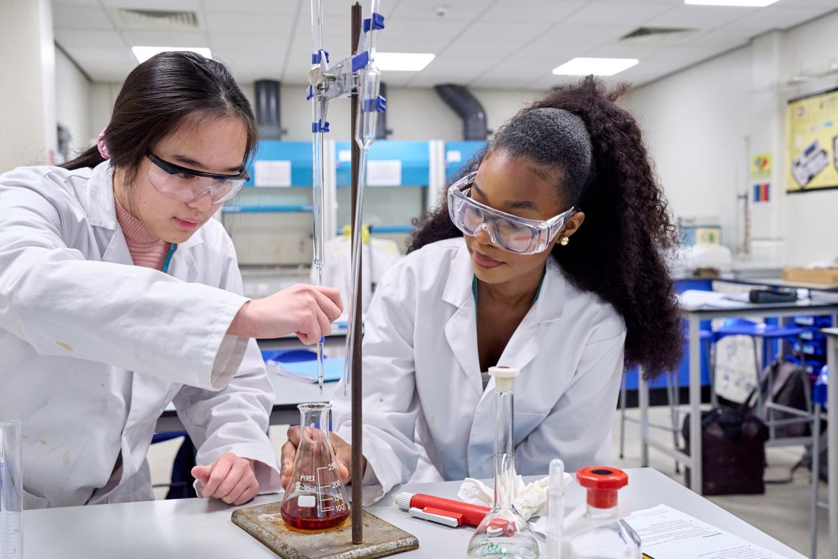2 science students carrying out a practical experiment in a lab