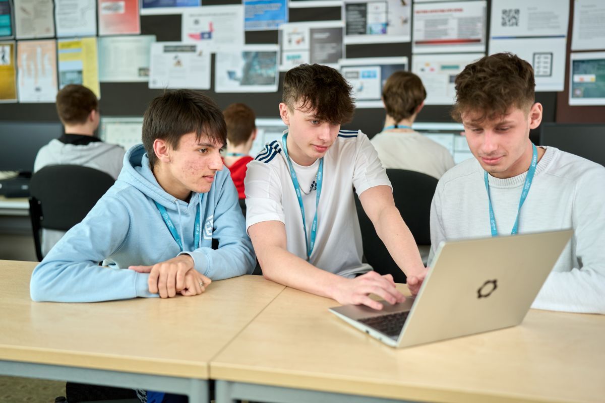 3 engineering students working on a laptop