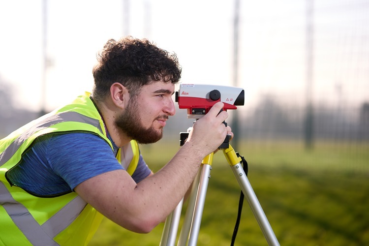 A Construction student uses a laser level tripod