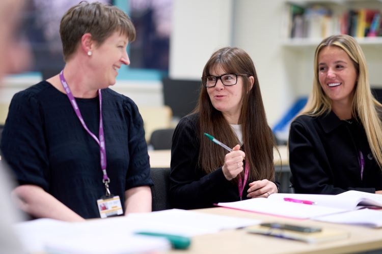 A group of students smile and chat in Spanish