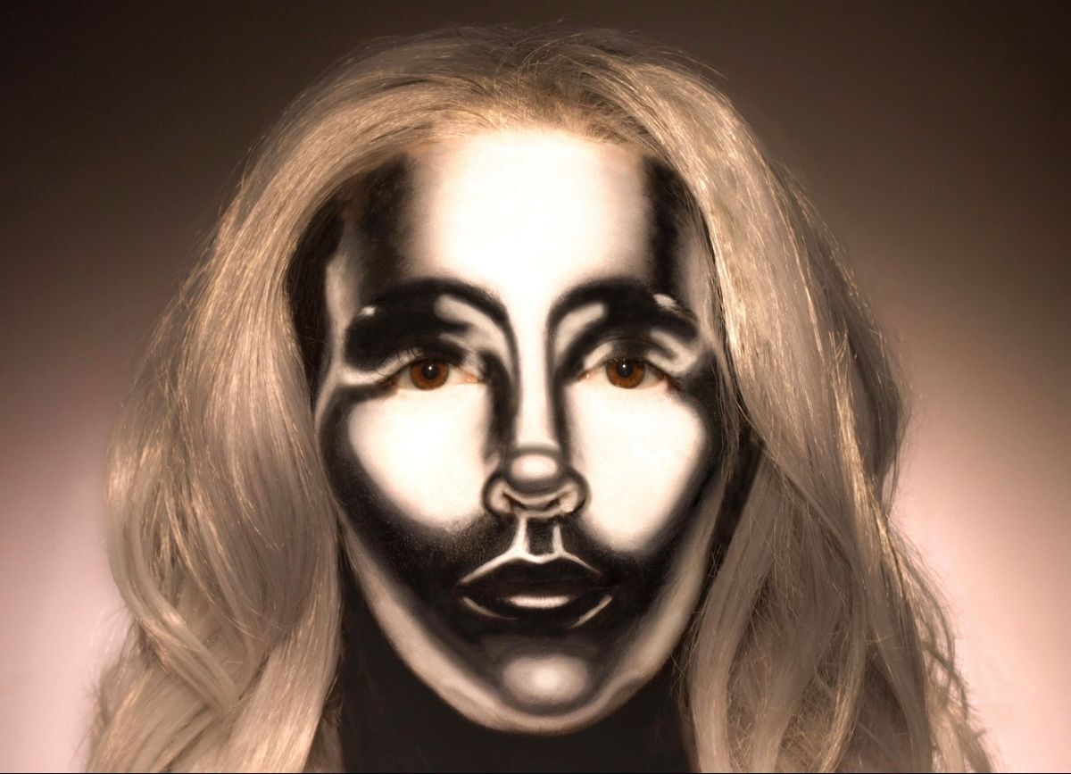 A metal mask with a blonde wig