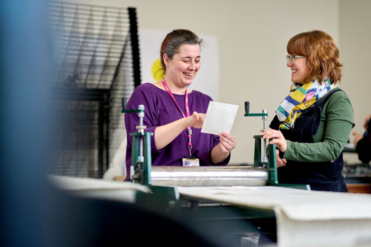 A student and a tutor look at a printing design Graphics