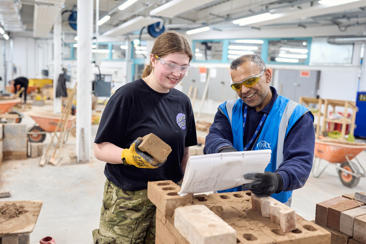 A student and tutor interact to build a wall Bricklaying Adult