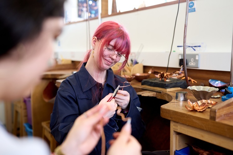 A student bends some copper Jewellery