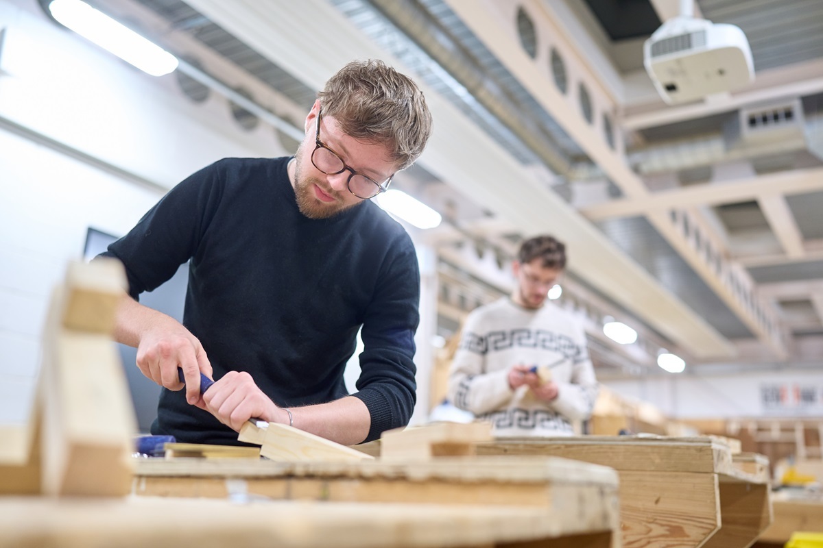 A student chisels some wood Joinery