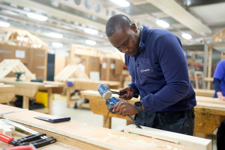 A student chisels some wood
