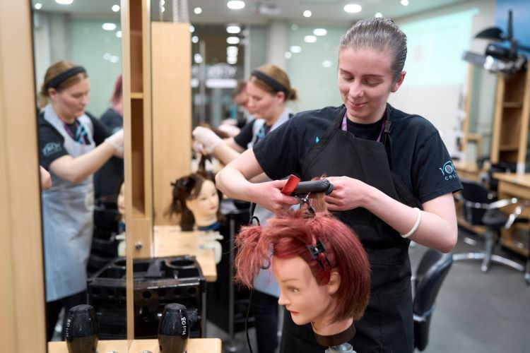 A student curls some hair