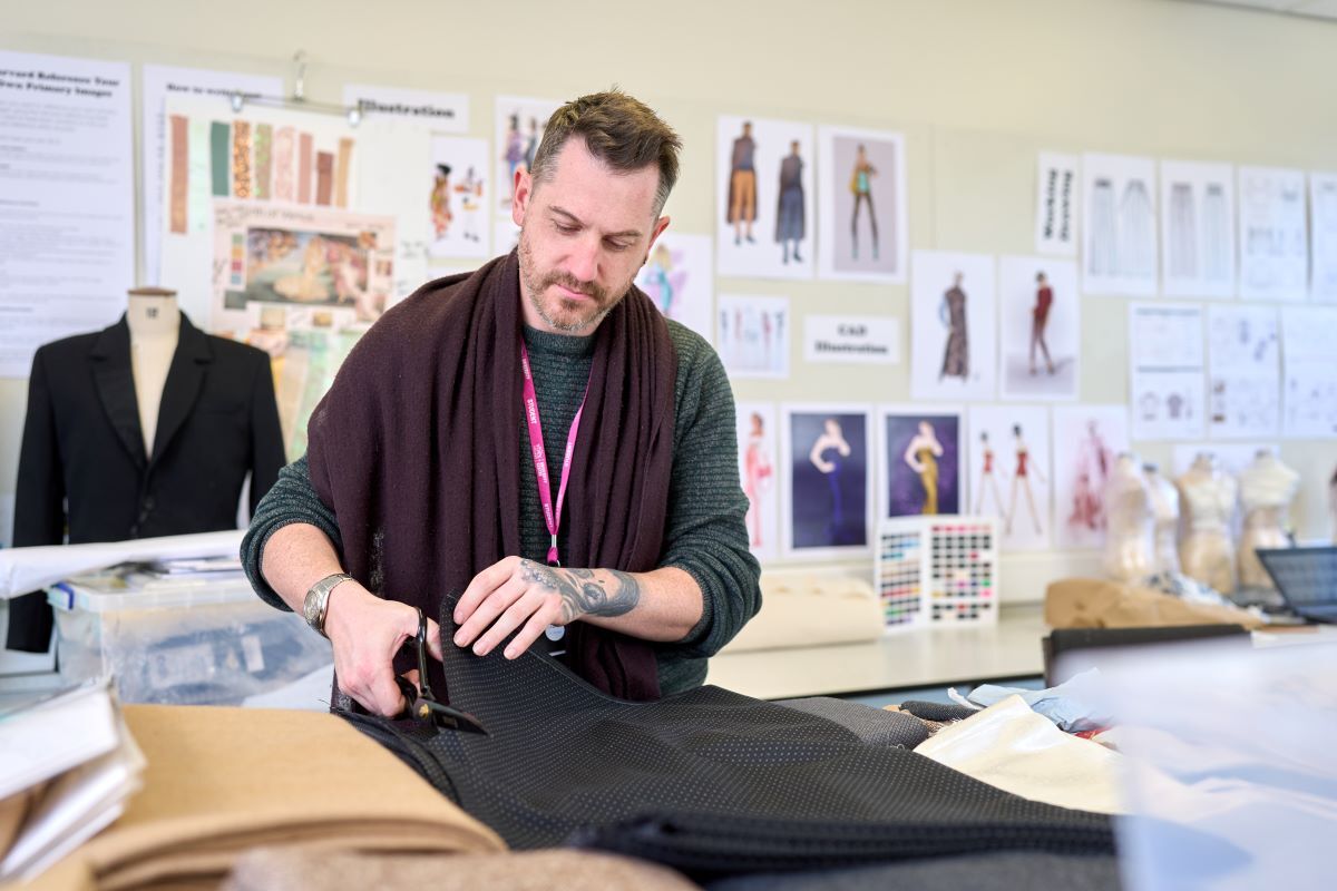 A student cuts some fabric Fashion