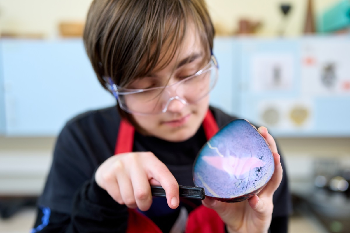 A student files a piece of rock 3 D