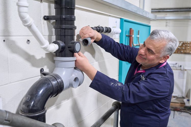 A student fixes some piping