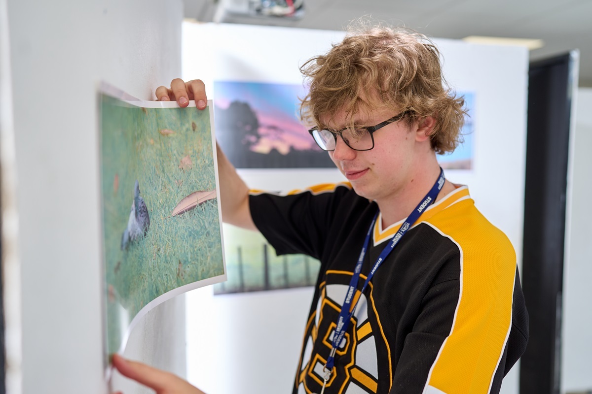 A student hangs his photo Photography