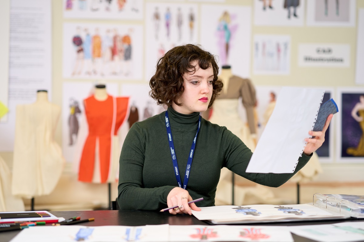 A student holds up a design Fashion