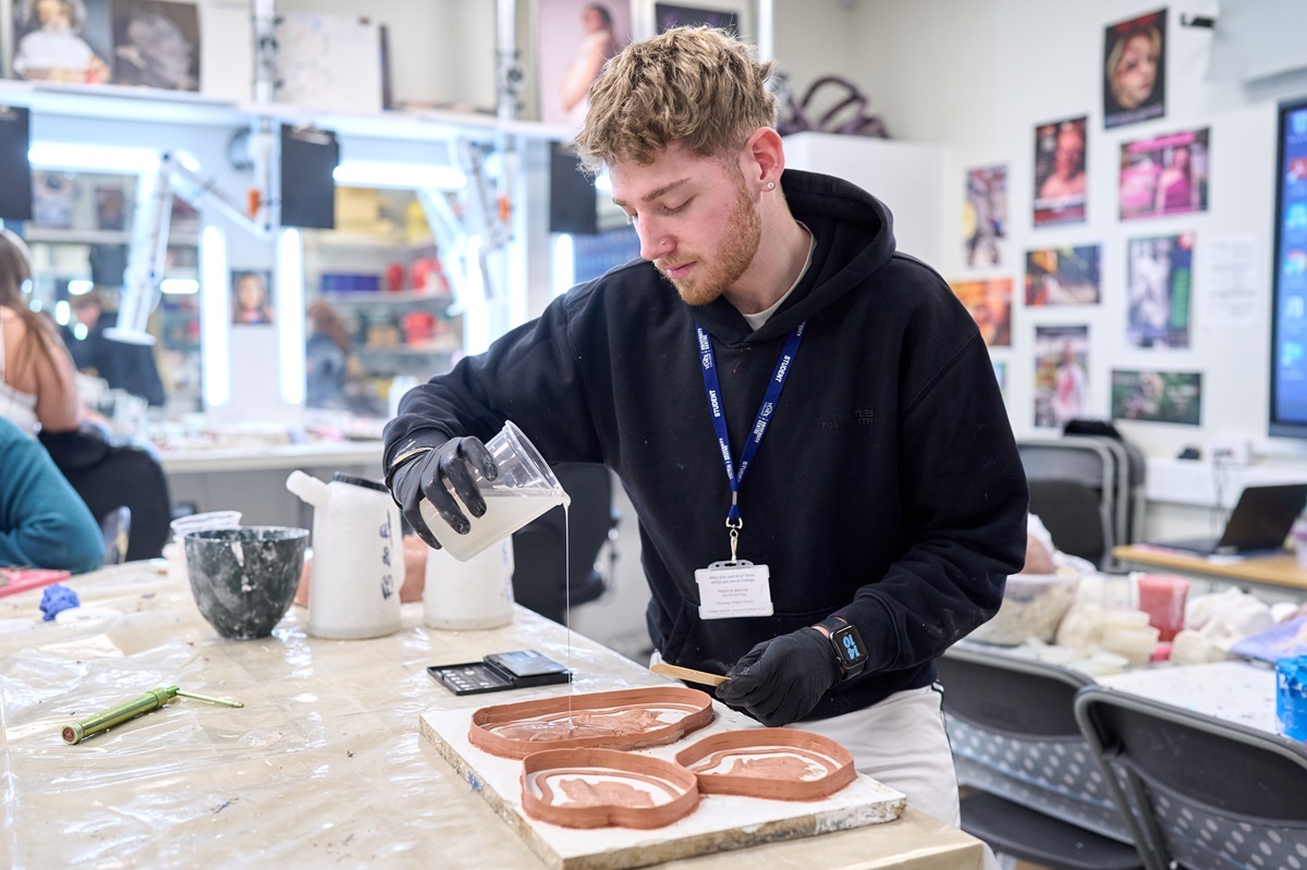 A student pours material into a mould Media Makeup