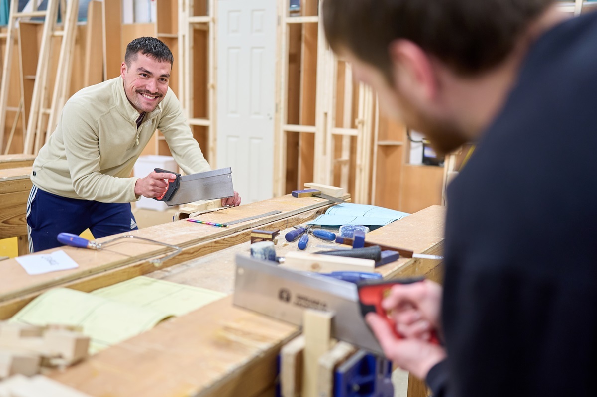 A student saws some wood Joinery