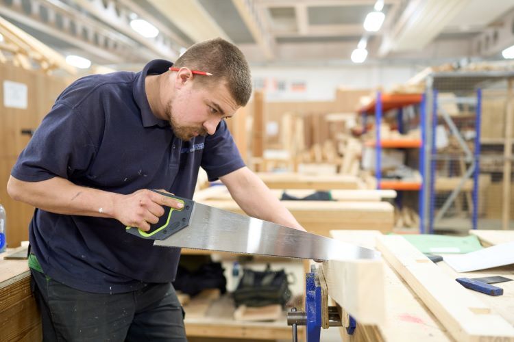 A student saws some wood