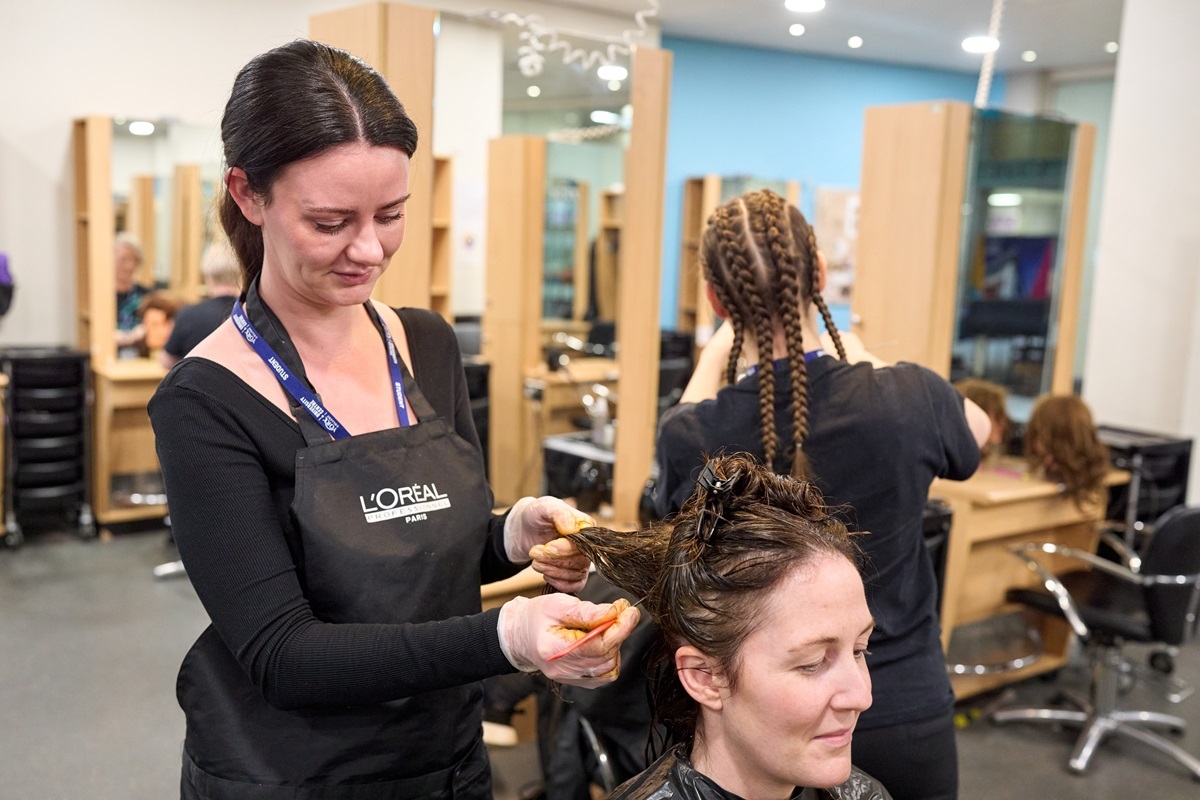 A student sections a clients hair for colouring Hairdressing
