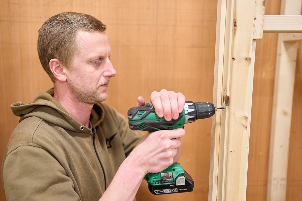 A student uses a drill on a door frame Joinery