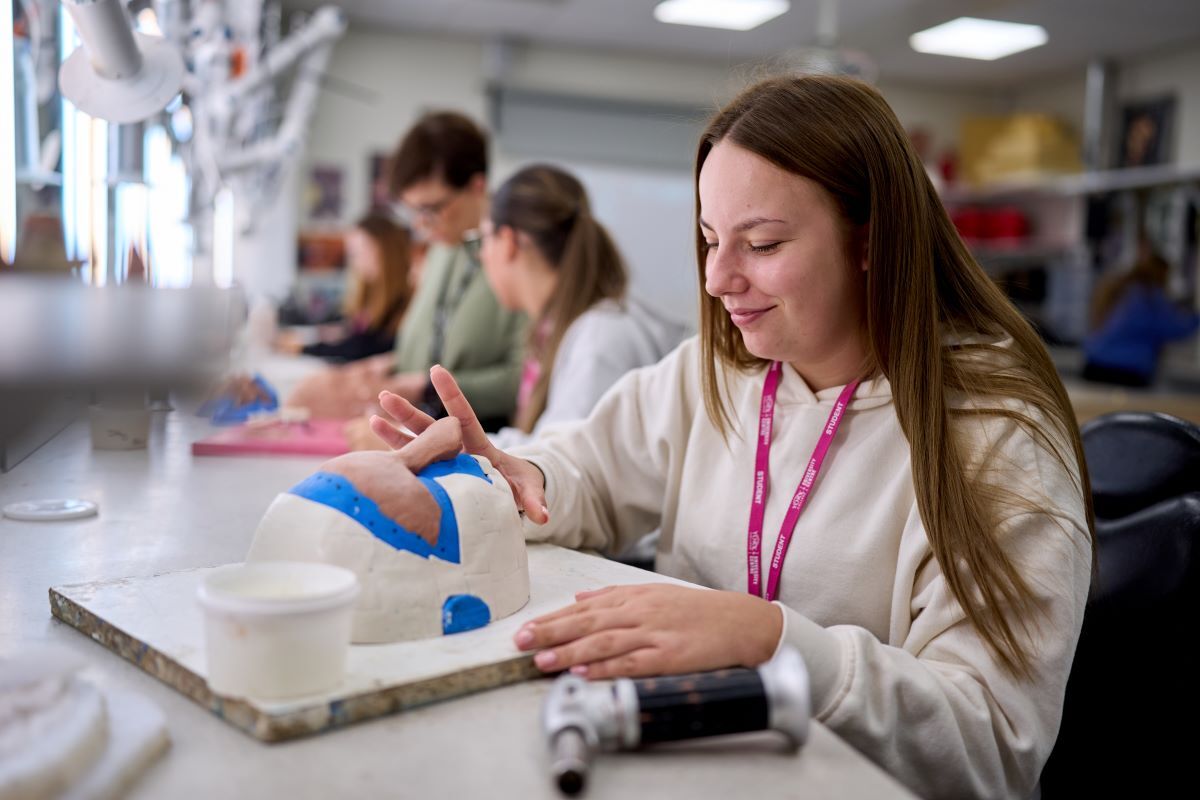 A student works on a prosthetic nose piece Media Make up