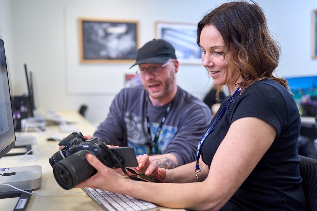 A tutor and student look at camera settings Photography