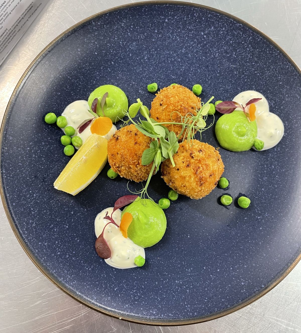 Arrancini balls with green and white sauces and peas
