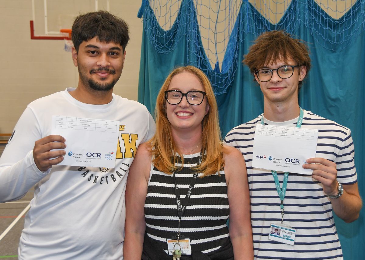 Azaan Iyer shows off his A Levels results in York Colleges Sports Hall with tutor Kayleigh Jude centre and another student on the right