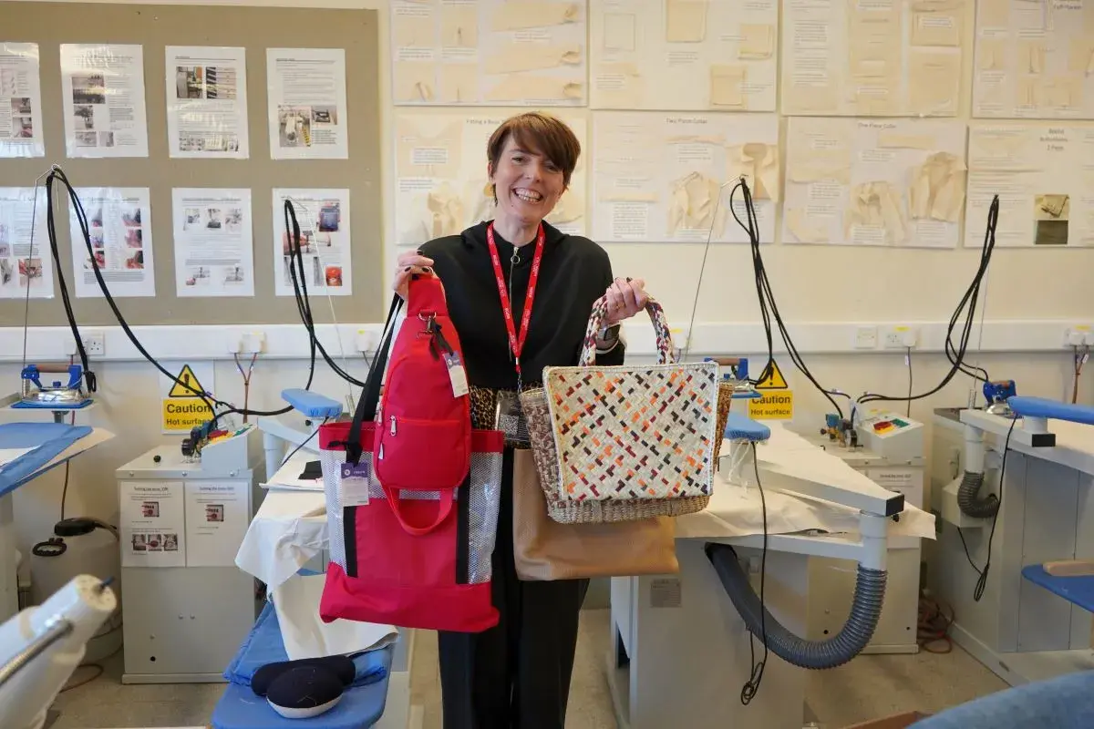Becky Oleary guest speaker in fashion wrokshop holding up recycled fashion items