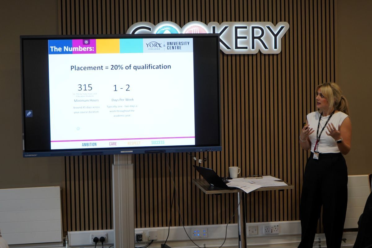 Emily Grimes addresses the audience in The Cookery to the side of a big screen