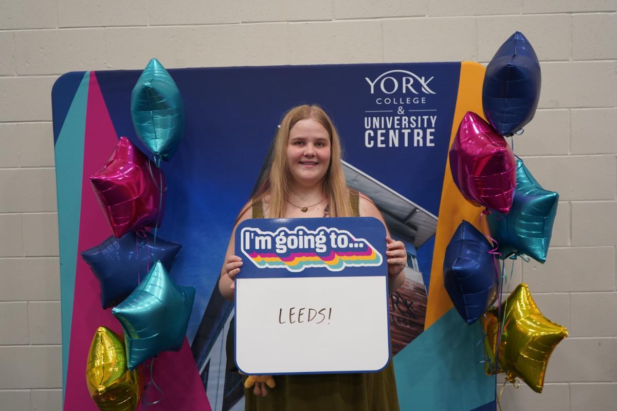 Genevieve Wynn holding sign that she is going to Leeds Uni