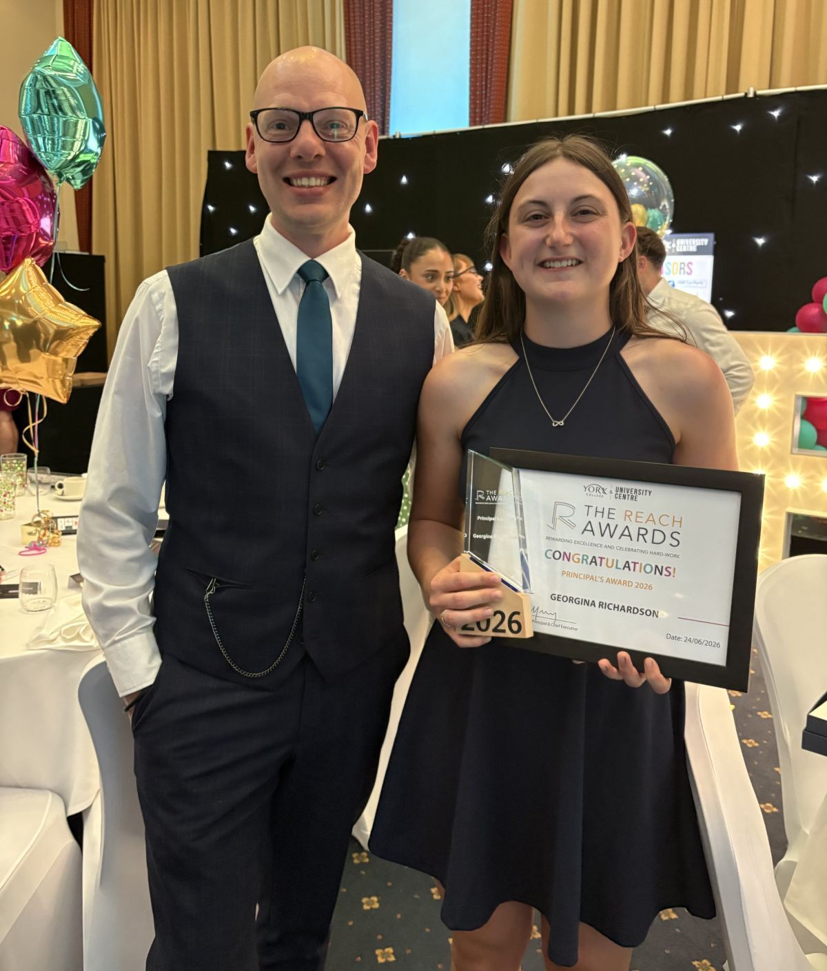 Georgina Richardson holds up her REACH Award certificate with tutor Neil Wilkinson at the ceremony