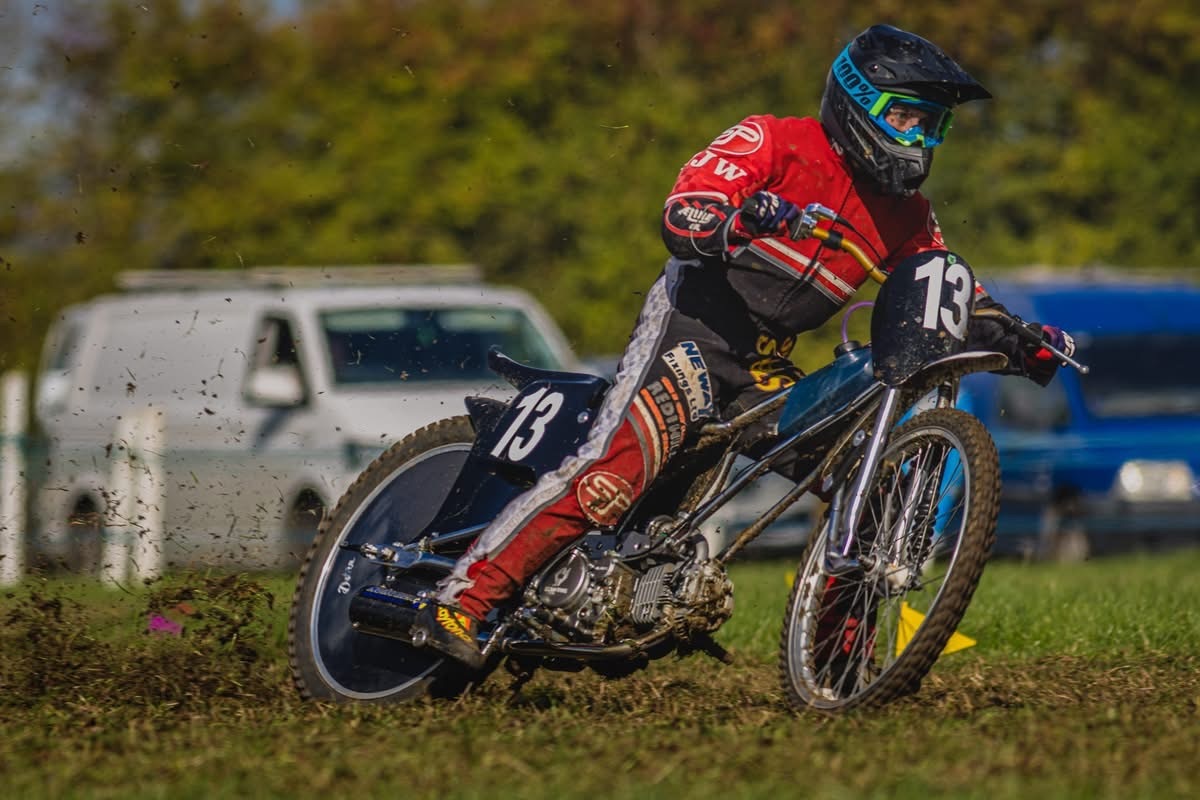 Georgina Richardson racing her motorbike on grasstrack with mud flying up from the back wheel