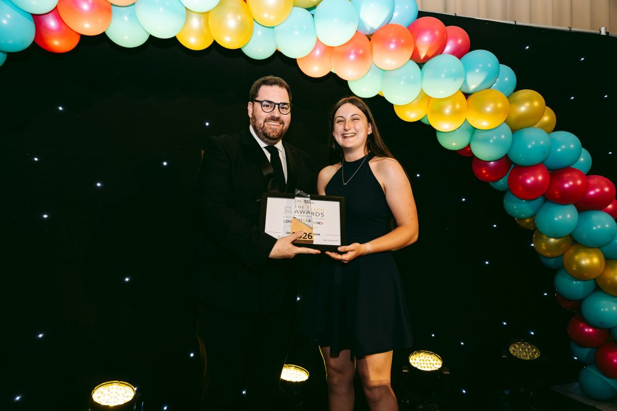 Georgina Richardson receives the Principals Award at the York College REACH Awards from Principal Ken Merry in front of a balloon arch
