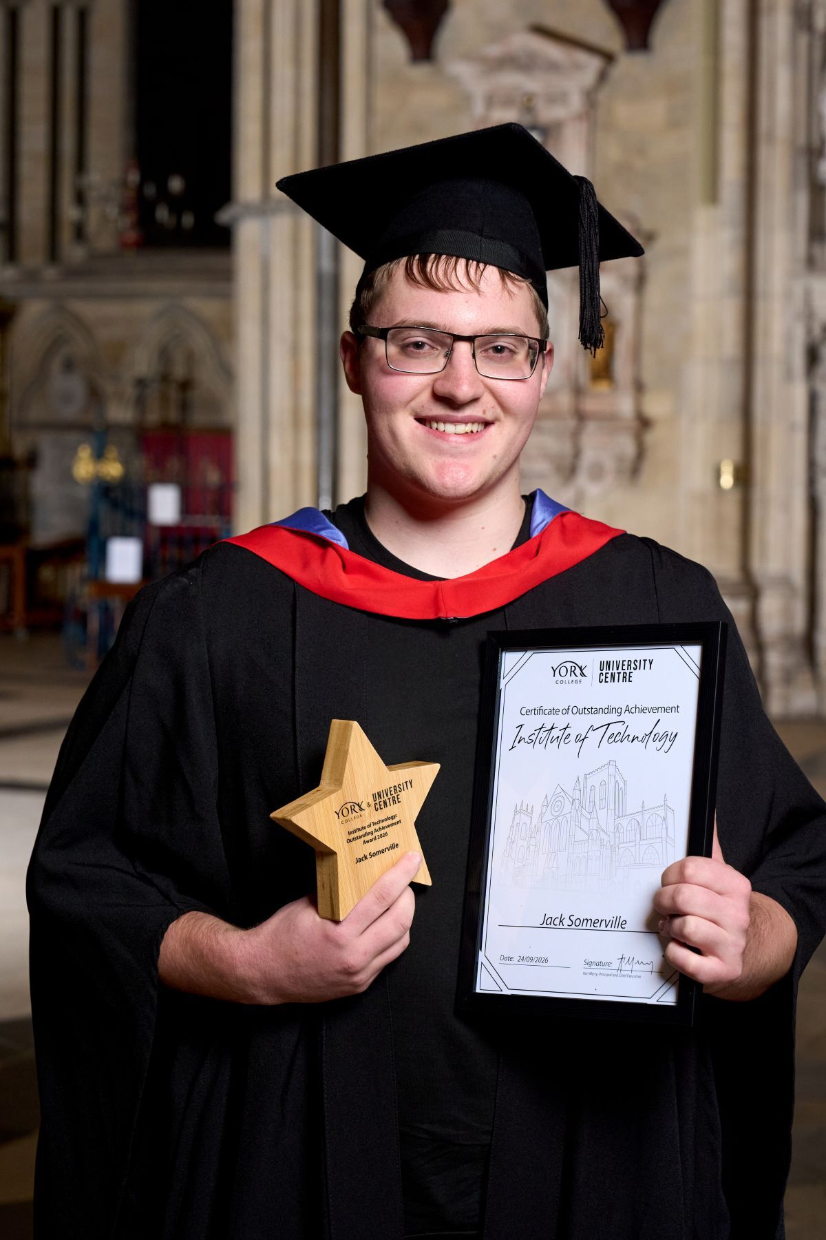 Jack Somerville holds his award and certificate at the York College University Centre Graduation Ceremony in York Minster