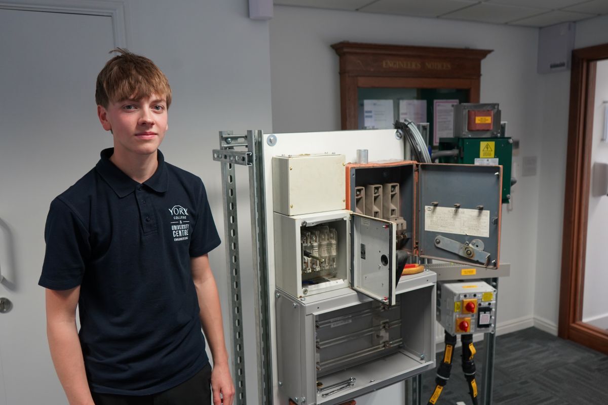 Jackson Hall stands next to an electrical engineering training unit in AGH Engineerings office