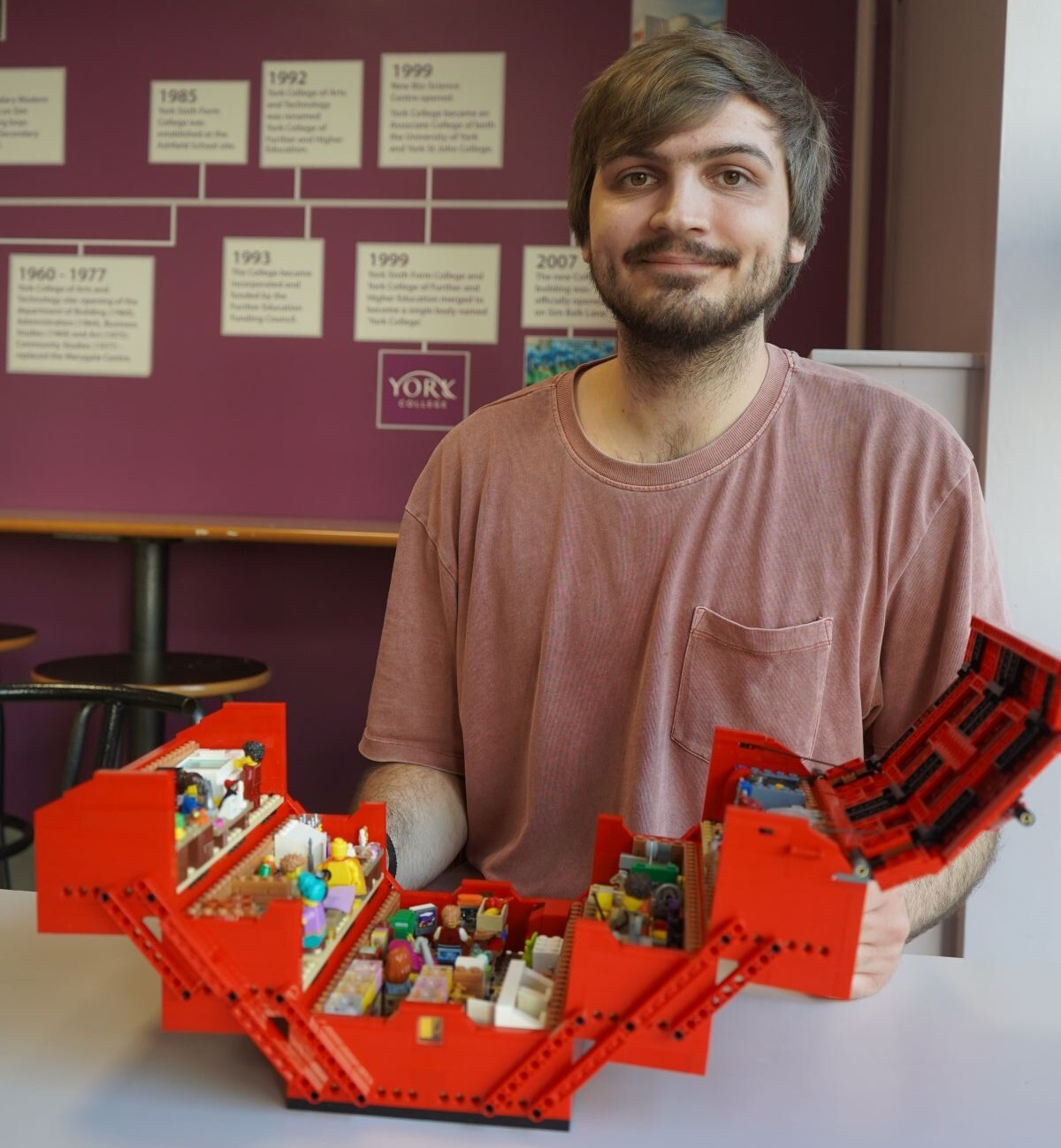 Joe Bailey poses behind his opened Workshop in a Toolbox Lego set