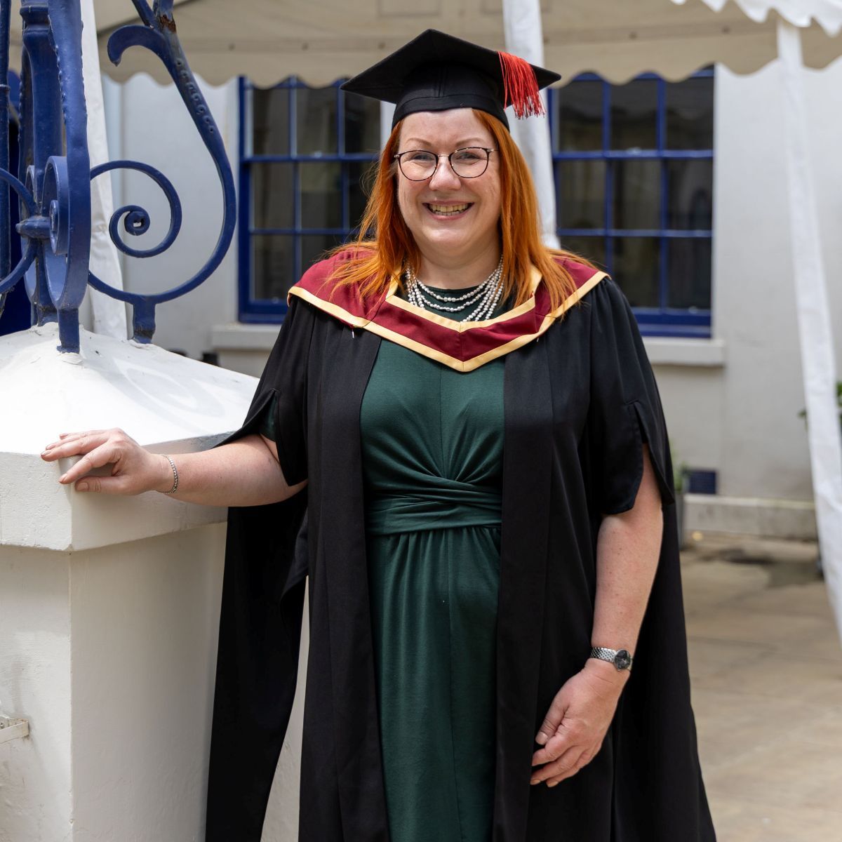Katharine Dent Jones dressed in gown and cap smiles outside in posed shot