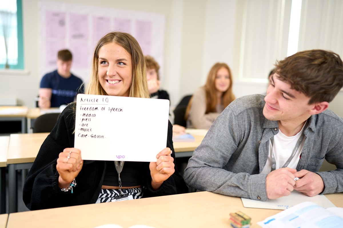 Law student holding a whiteboard with answers to questions