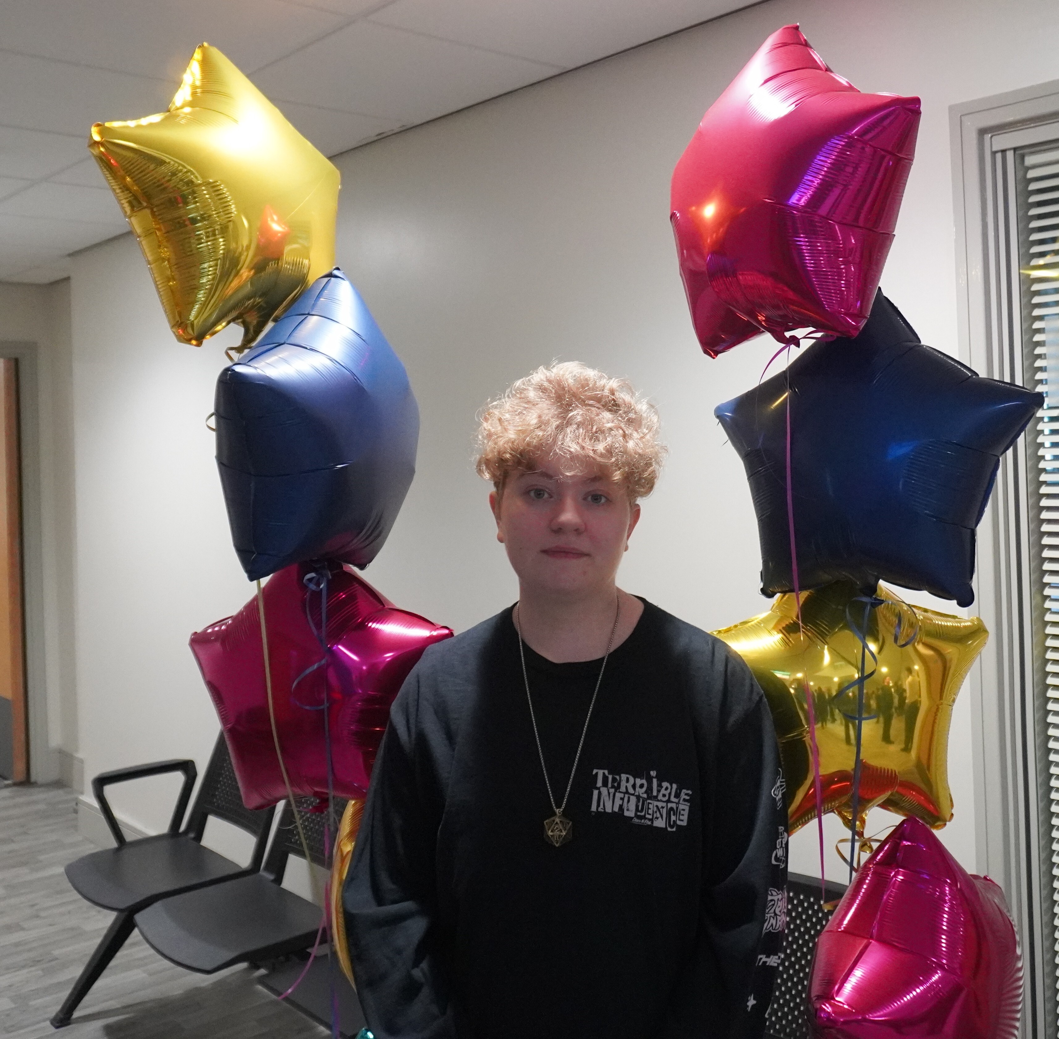 Milo Bove celebrates his GCSE result with star shaped balloons
