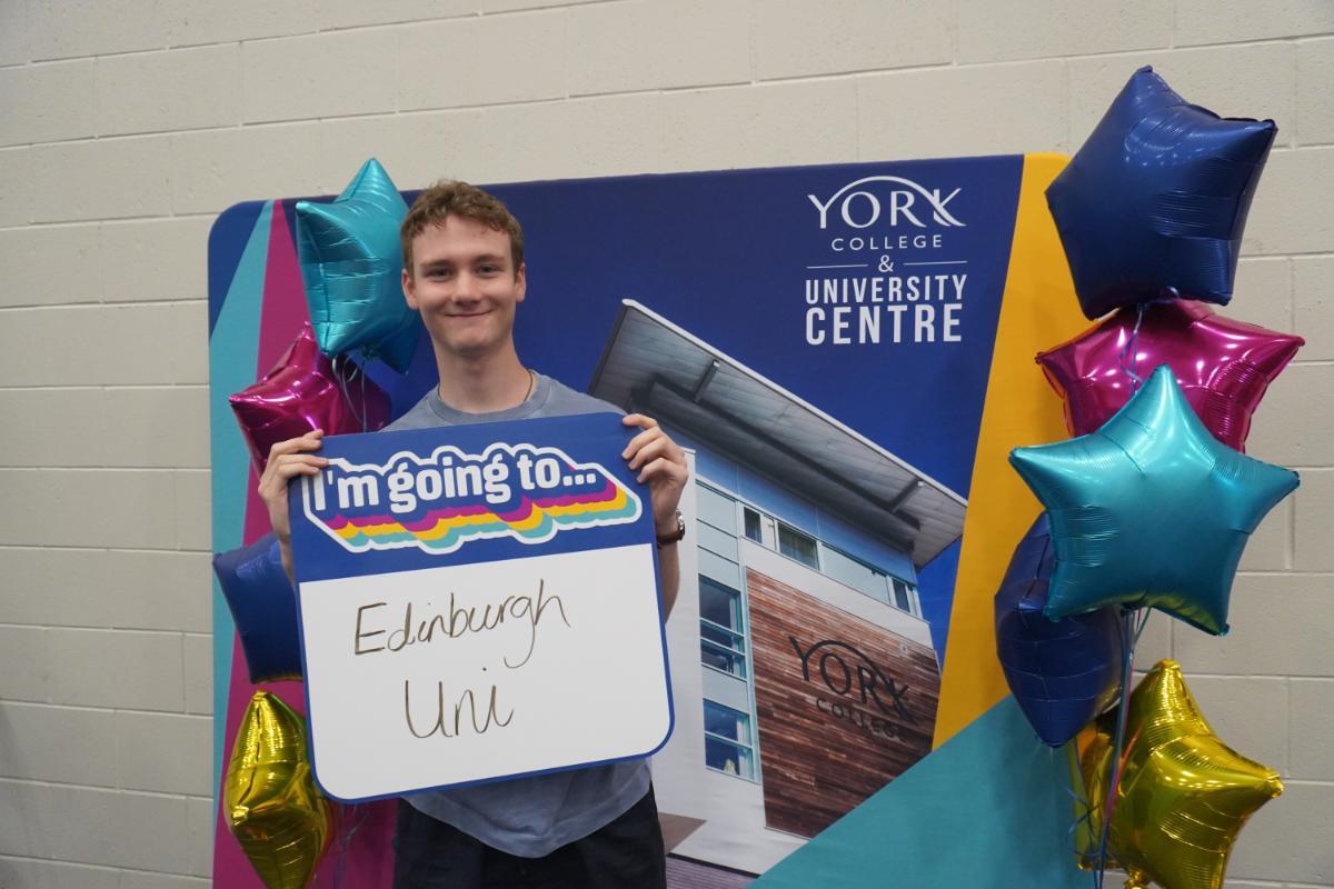 Peter Foster on results day with sign going to Edinburgh uni