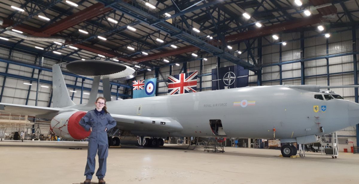 Robyn Bradley in work clothes in front of an RAF E 3 D Sentry plane in its hangar