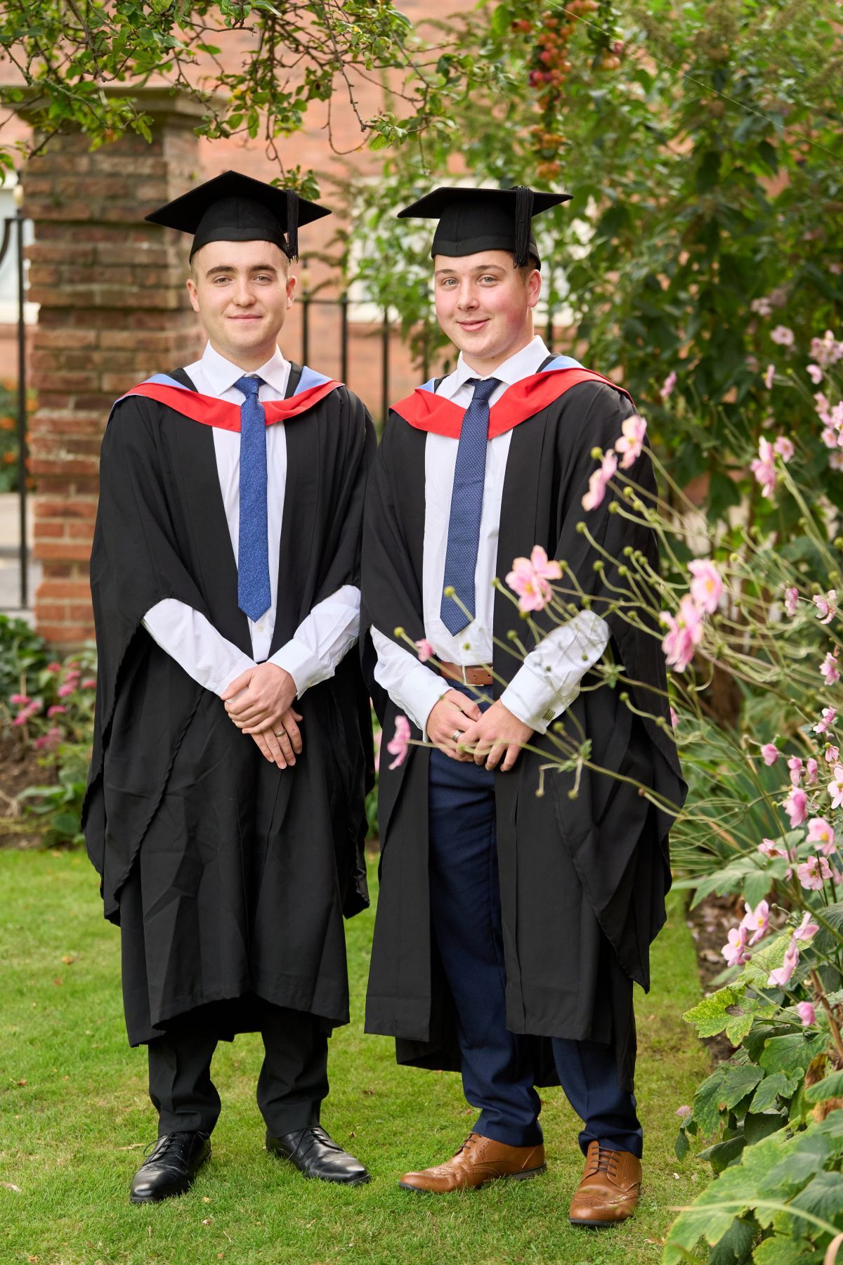 Sam Welch on right and Ewan Tumilty stood in the grounds of the Merchant Taylors Hall looking at the camera after being fitted with their graduation gowns cap and sash