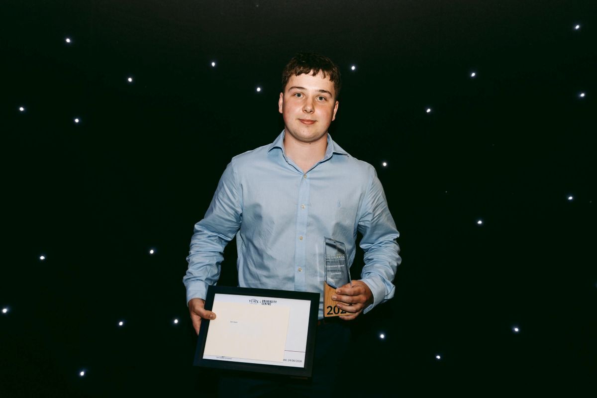 Sam Welch poses with his REACH Award