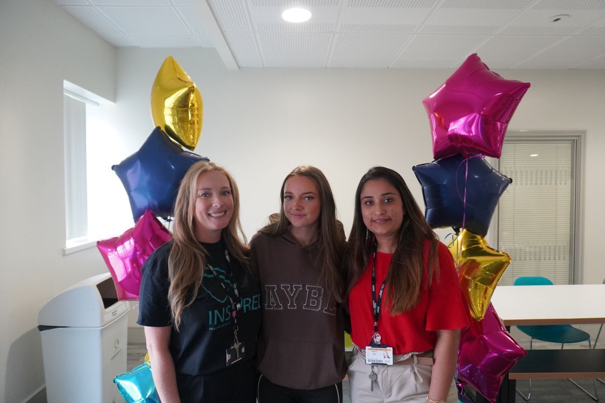 Sophie Chaplin celebrates her GCSE results by posing with tutors Laura Heward left and Naduni Silva right accompanied by star shaped balloons