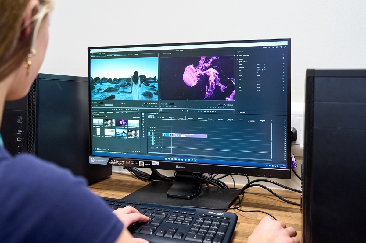 Student sitting at a PC editing video footage