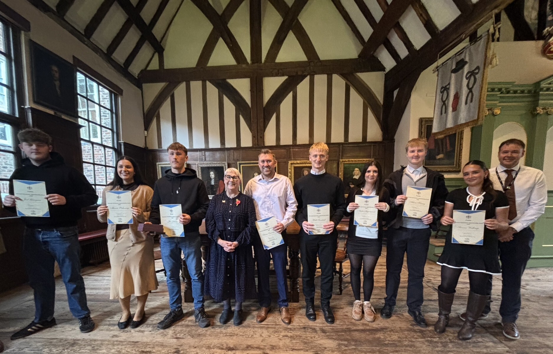 The Merchant Adventurers Award finalists stand with their certificates along with Company Governor Professor Sarah Brown and Ash Stokes of York College in The Merchant Adventurers Hall