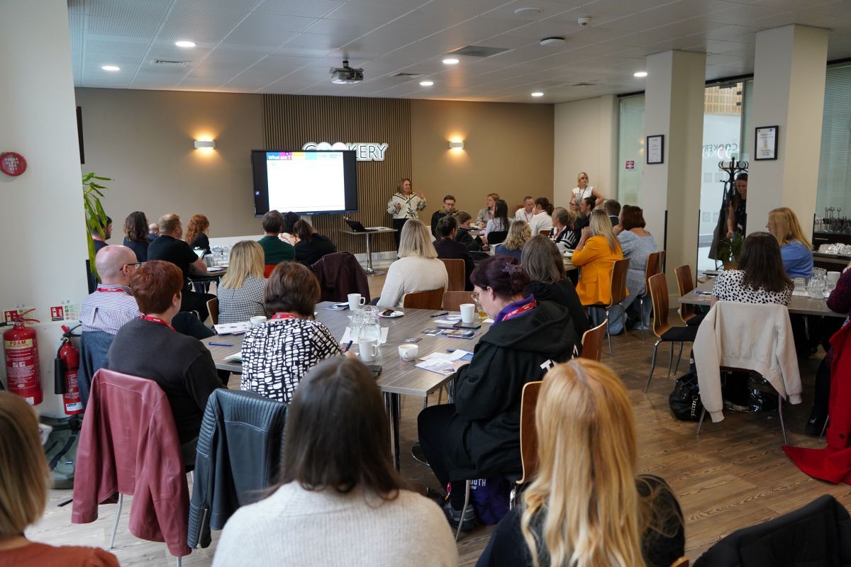 The backs of heads of the audience listening to Liza Bradley in The Cookery