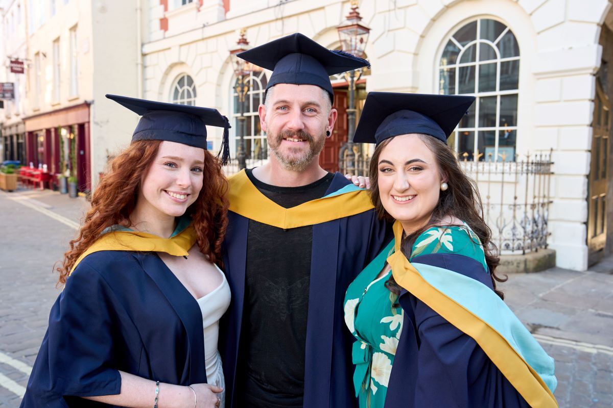 Three students celebrate at graduation University Centre