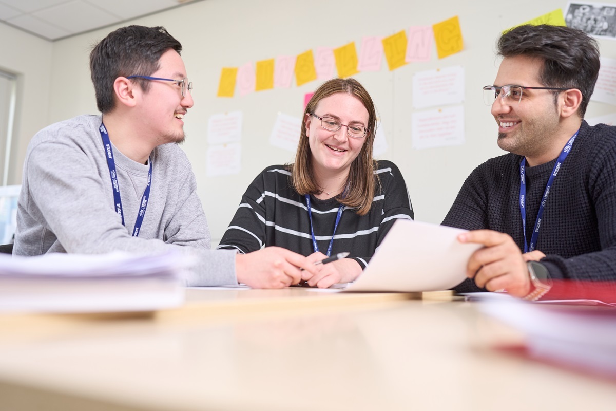 Three students smile at eachother GCSE English