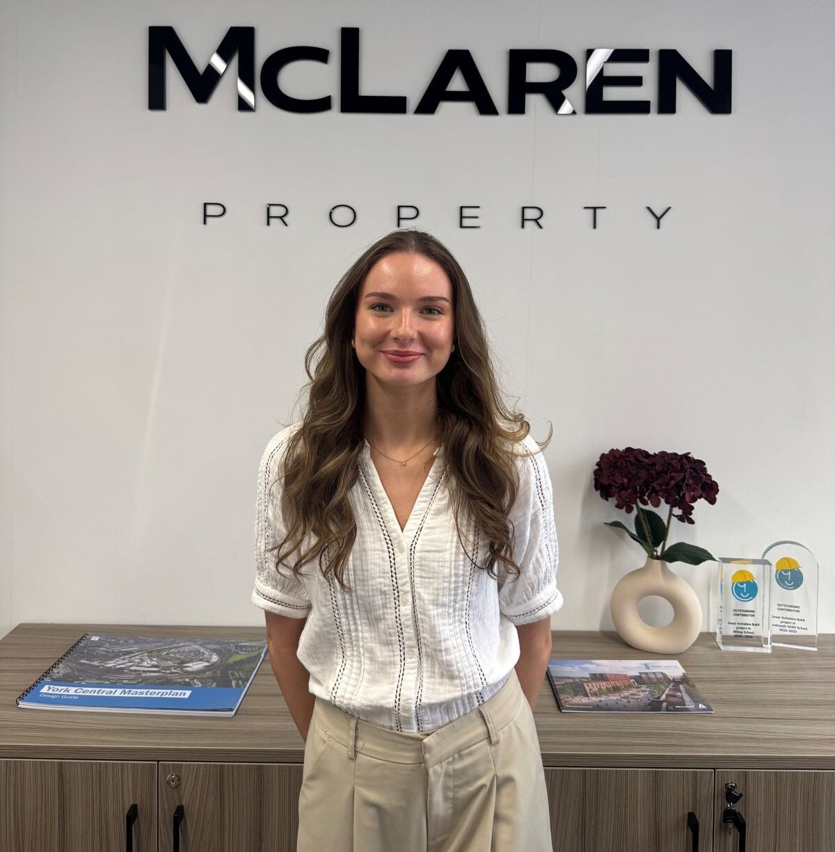 Tilly Allan poses in front of Mc Laren Property branding at the companys office