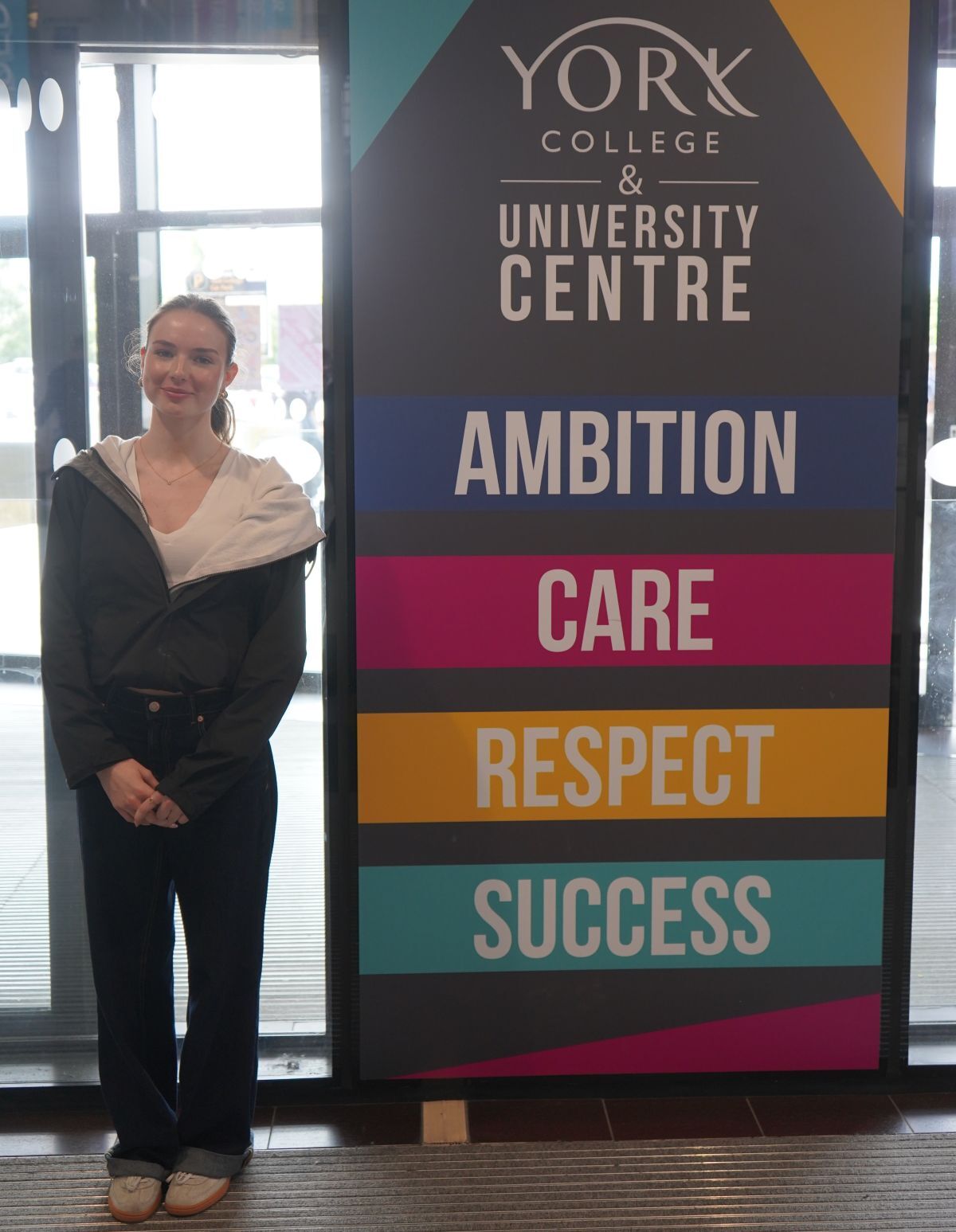 Tilly Allan poses next to York College values banner near front entrance