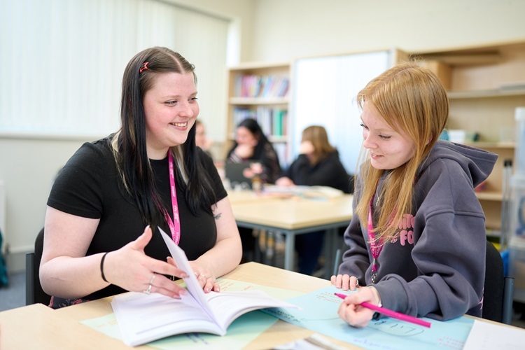 Two Child Development students smile and work